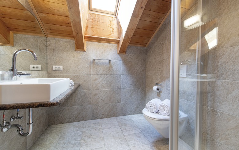 La foto mostra il bagno con lavandino, doccia e servizi igienici.