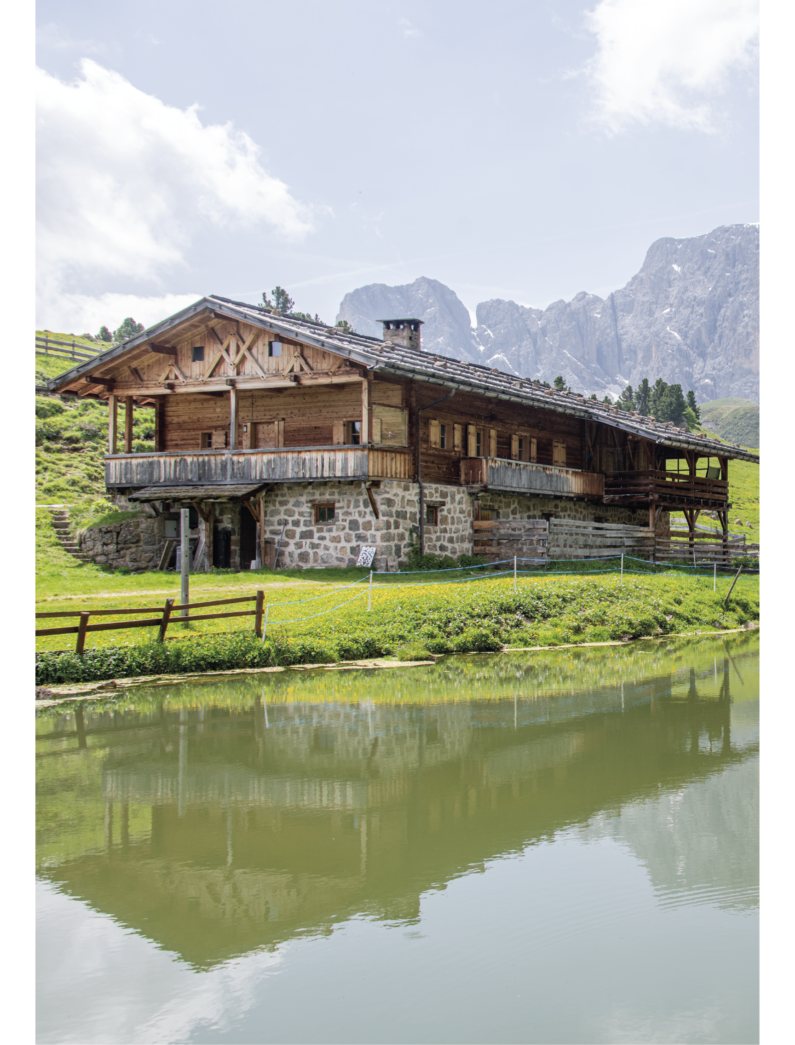 Rifugio Molignon Alpe di Siusi | Esperienze speciali in montagna all'Alpe di Siusi L'immagine mostra un rifugio con il monte Molignon sullo sfondo e il lago in primo piano.