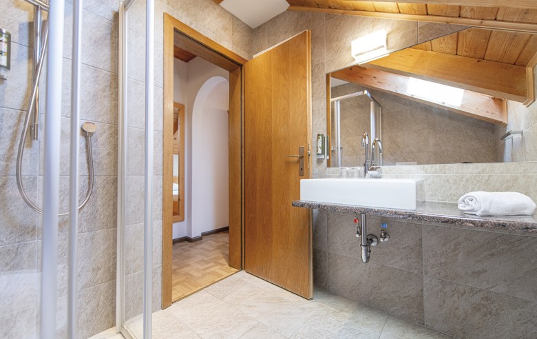 La foto mostra il bagno con lavandino e doccia.