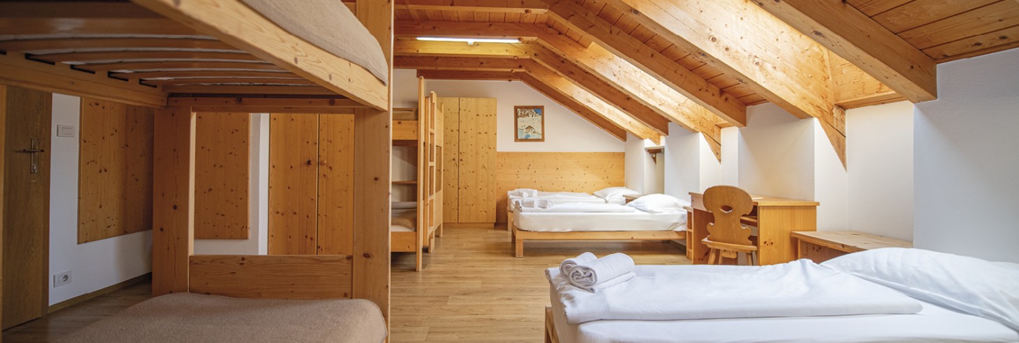 Rifugio Molignon Alpe di Siusi | Vivere il fascino alpino: il nostro accogliente rifugio sull'Alpe di Siusi La foto mostra il letto a castello con letti singoli e a castello.