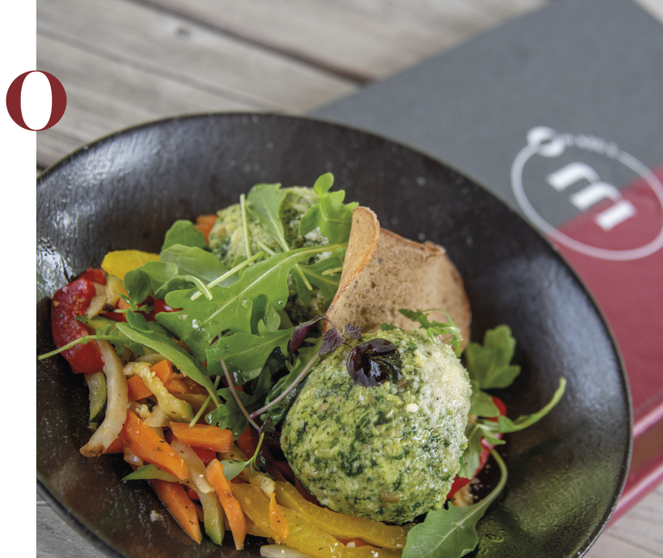 Schutzhaus Molignon Alpe di Siusi/Seiser Alm | Enjoy delicious dishes with a special view of the Dolomites. The picture shows a spinach dumpling on rocket and wok vegetables.