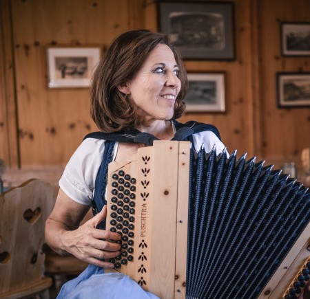 Molignon Alpe di Siusi refuge | Unique impressions of the Alpe di Siusi The picture shows the hostess Meggi playing the accordion.