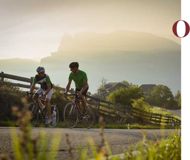 Rifugio Molignon Alpe di Siusi | Ciclismo deluxe: Alpe di Siusi, Dolomiti e le impressionanti colline di fondo e piano L'immagine mostra due ciclisti sull'Alpe di Siusi. Sullo sfondo si vede lo Sciliar.