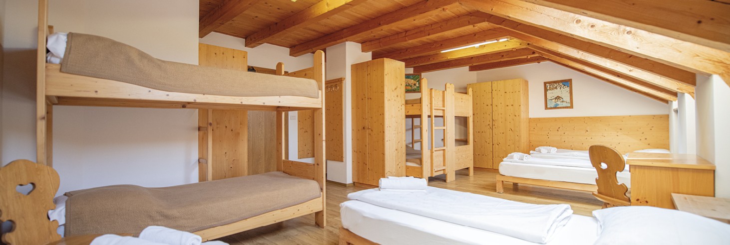 Rifugio Molignon Alpe di Siusi | Rifugio e riposo nel nostro rifugio: Fuggite dalla quotidianità in montagna La foto mostra il materasso. Si possono vedere letti singoli e a castello, così come un armadio e diverse scrivanie.