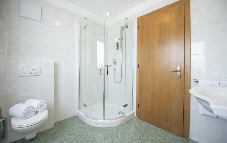 La foto mostra il bagno con doccia, WC e lavandino.