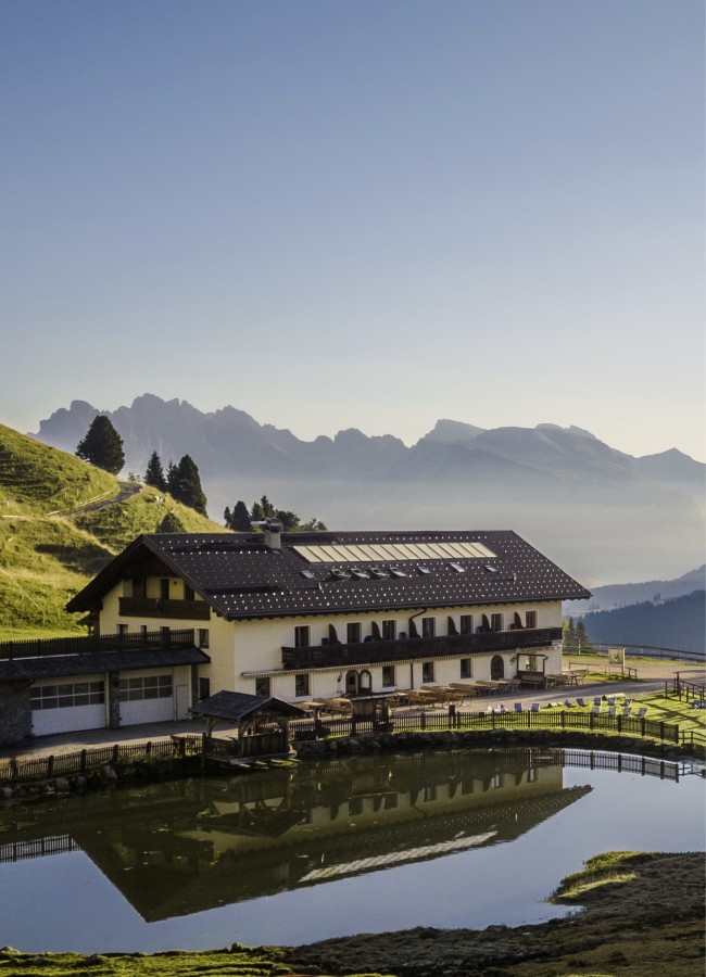 Das Bild zeitgt die Molignonhütte mit dem See und im Hintergrund befindet sich eine Bergkette.