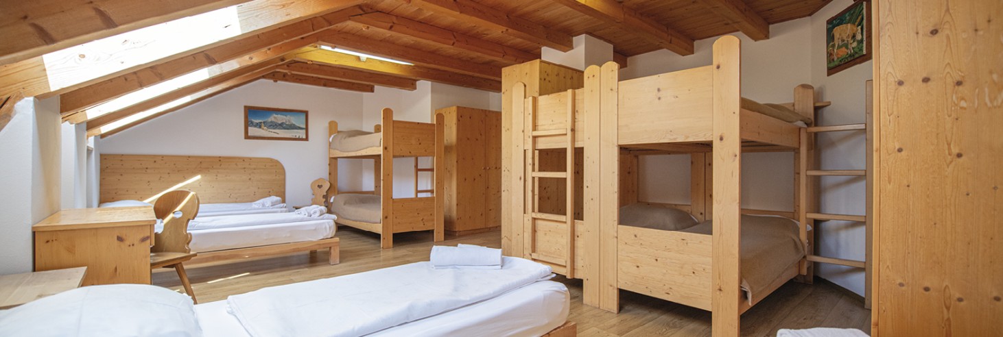 Rifugio Molignon Alpe di Siusi | Un angolo di paradiso alpino: il nostro rifugio per autentiche avventure alpine La foto mostra il materasso. Si vedono letti singoli e a castello.